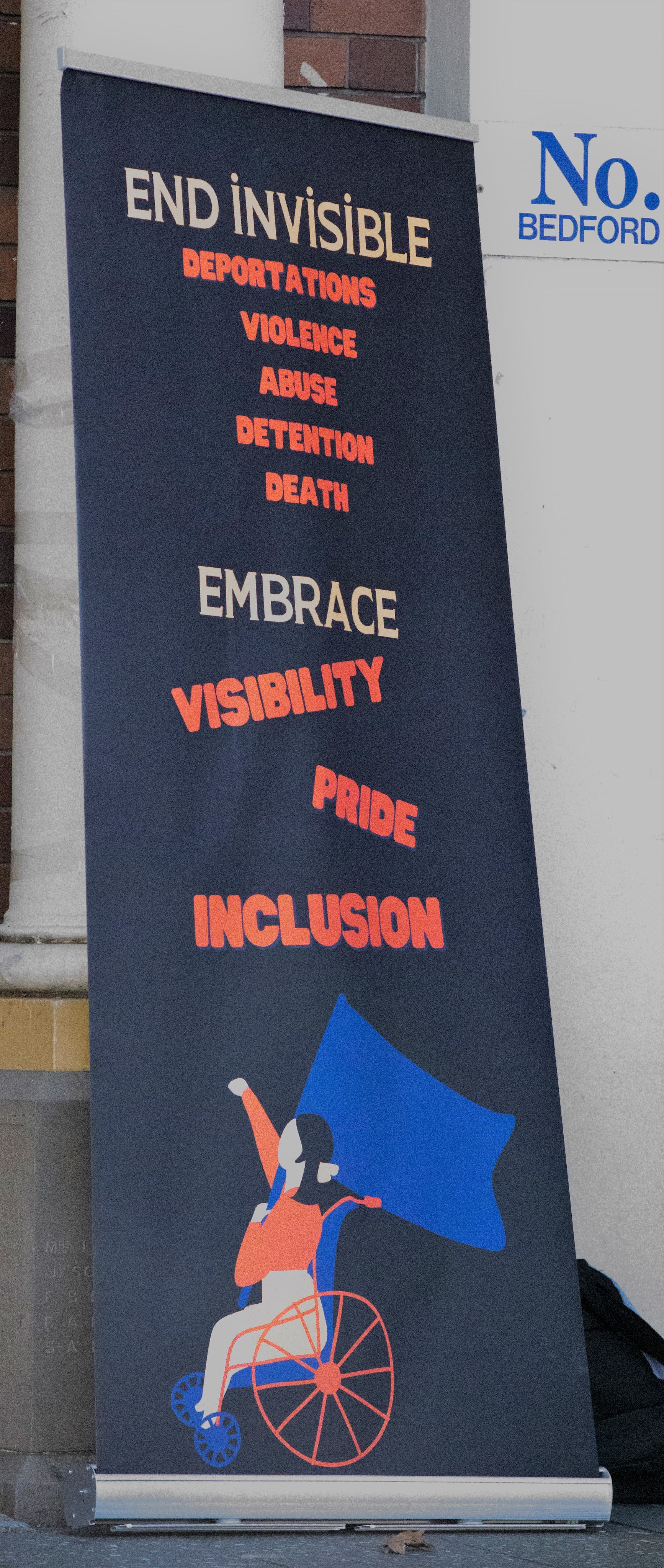 Banner reading "End invisible violence, abuse, detention, death. Embrace visibility, pride, inclusion